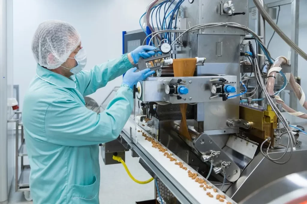 Técnico farmacêutico trabalhando com equipamentos na indústria farmacêutica